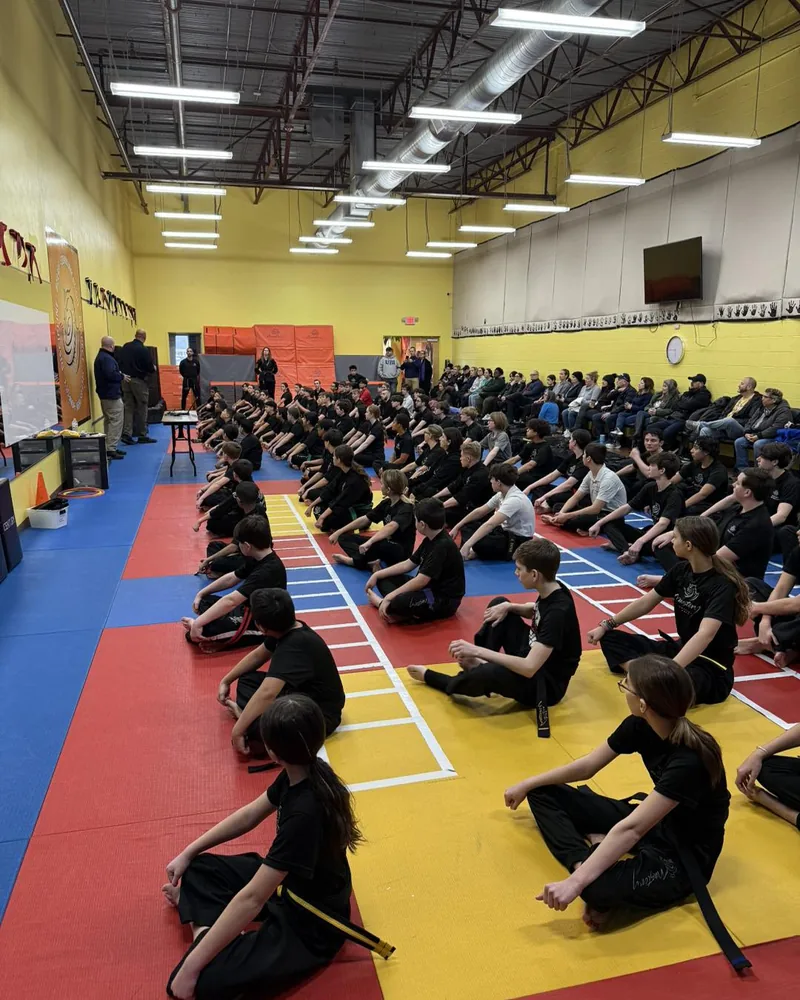 Kids martial arts class seated on mats at Mastery Martial Arts Troy MI