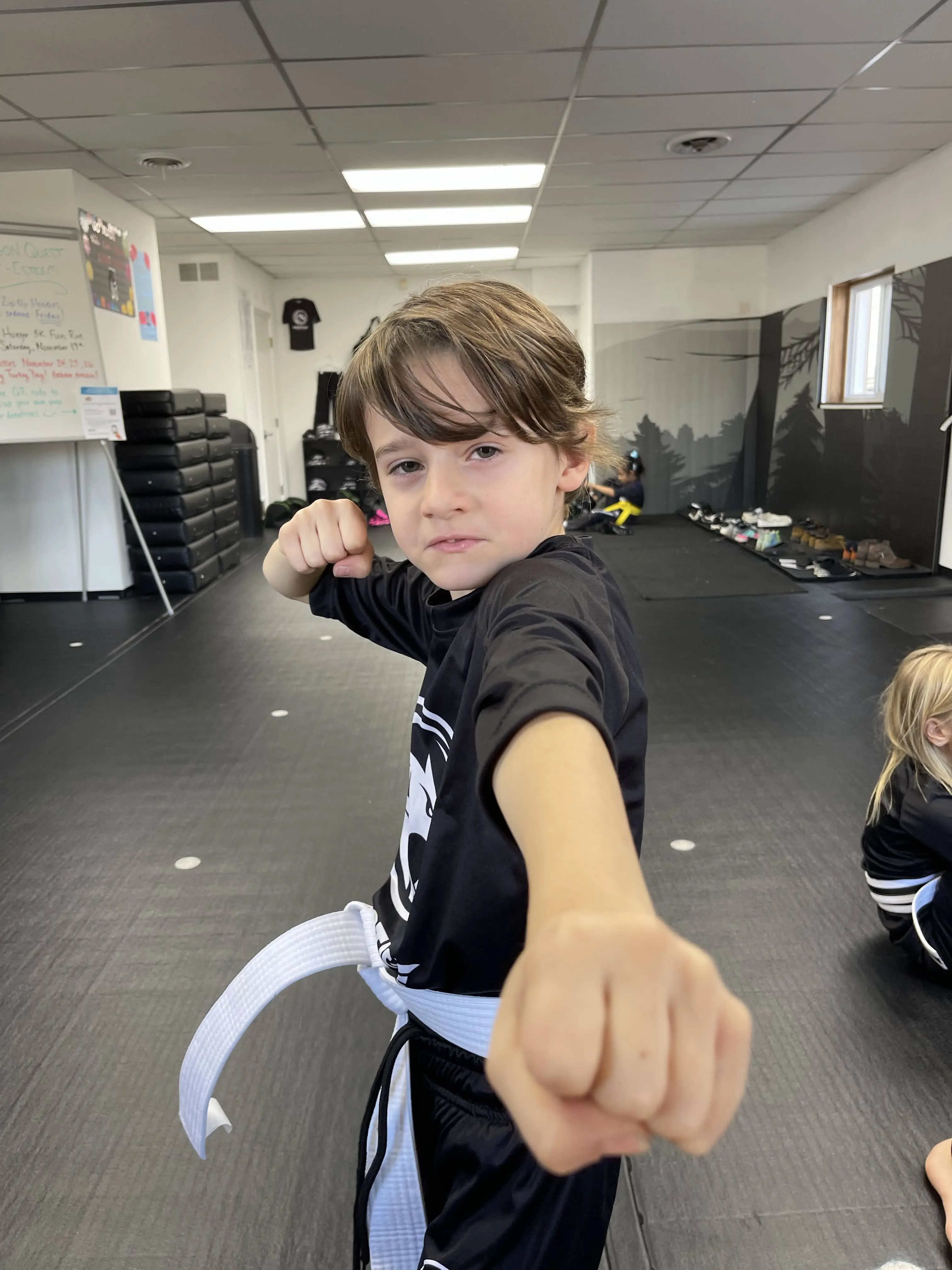 Black Belt Story – Avi Braun 8 Avi Braun standing proud in martial arts gi at Mastery Martial Arts dojo in Troy Michigan