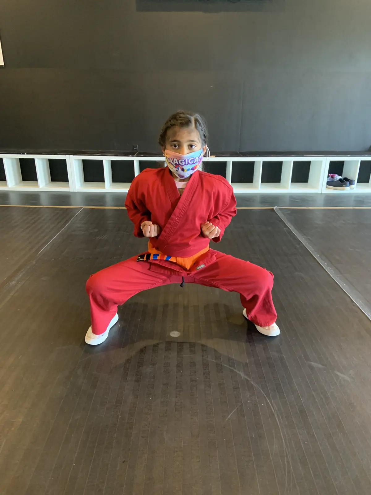 Black Belt Story – Falak Kotadia 1 Falak Kotadia in red martial arts gi showing confidence and pride in the dojo at Mastery Martial Arts Troy Michigan