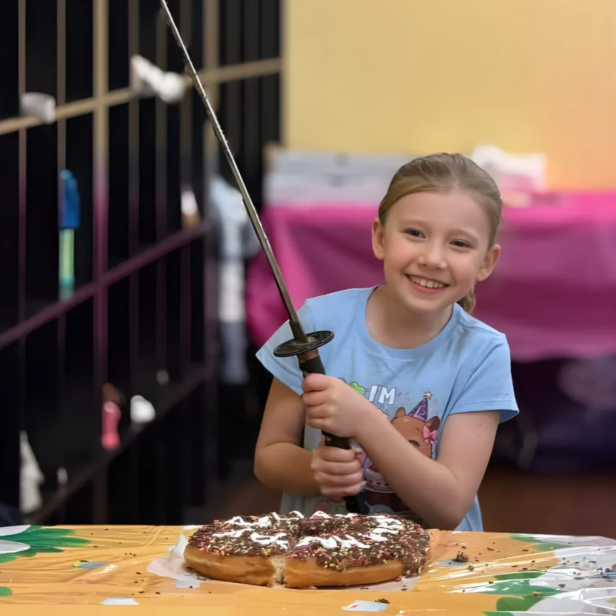 Birthday child cutting her cake with the Mastery samurai sword
