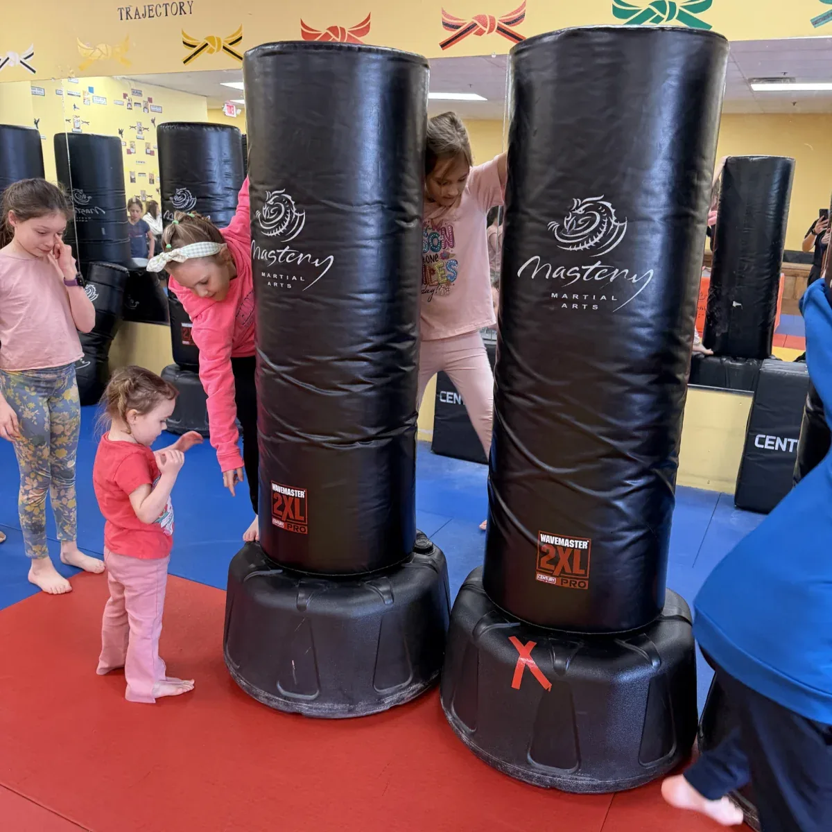 Children taking turns on the training bags during a Mastery birthday party